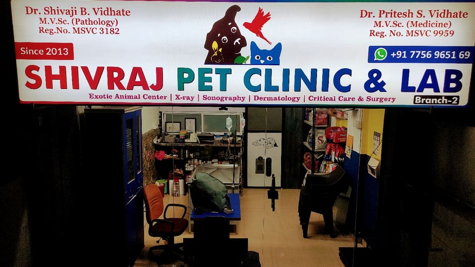 Illuminated Shivraj Pet Clinic & Lab signboard naming Dr. Shivaji B. Vidhate and Dr. Pritesh S. Vidhate above the clinic entrance at night