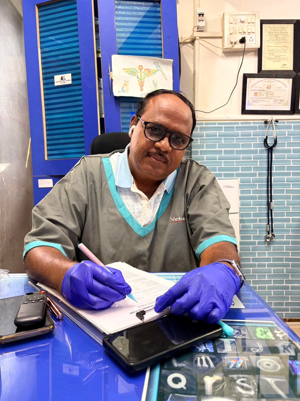 Dr. Shivaji Vidhate writing clinical notes after an examination