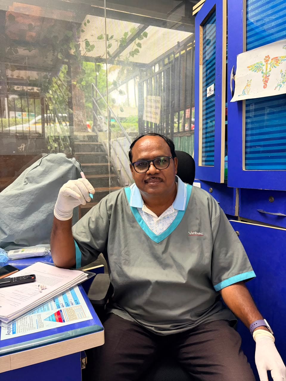 Dr. Shivaji Vidhate smiling at the clinic in grey scrubs