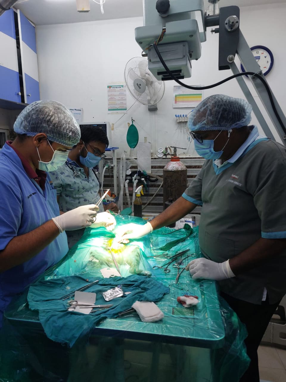 Surgical team operating with the X-ray arm positioned overhead